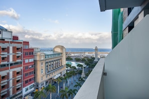 A high-rise building with a view of a beach and a monument.