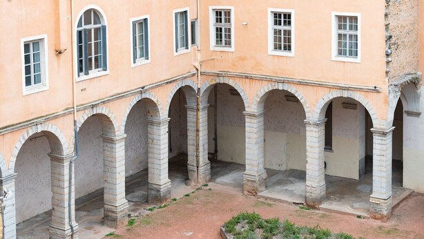 A courtyard with stone arches and a garden area. - Bright and quiet apartment in the heart of Lyon (Lyon)