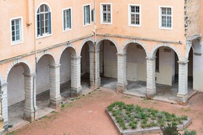 A courtyard with stone arches and a garden area.