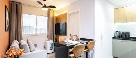 A modern apartment with a dining area, kitchen, and living space.