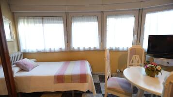 Habitación cuádruple, vista a la ciudad | Escritorio, espacio para trabajar con laptop y cortinas blackout