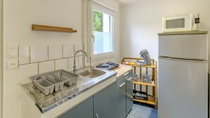 A compact kitchen with a sink, a microwave, and a refrigerator.