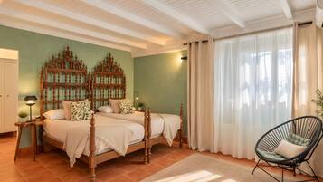 Un dormitorio con una cama grande, dos mesitas de noche, una silla y un panel decorativo en la pared.