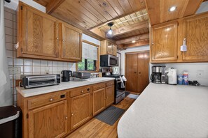 A kitchen with wooden cabinets, a microwave, a toaster, and a coffee maker.