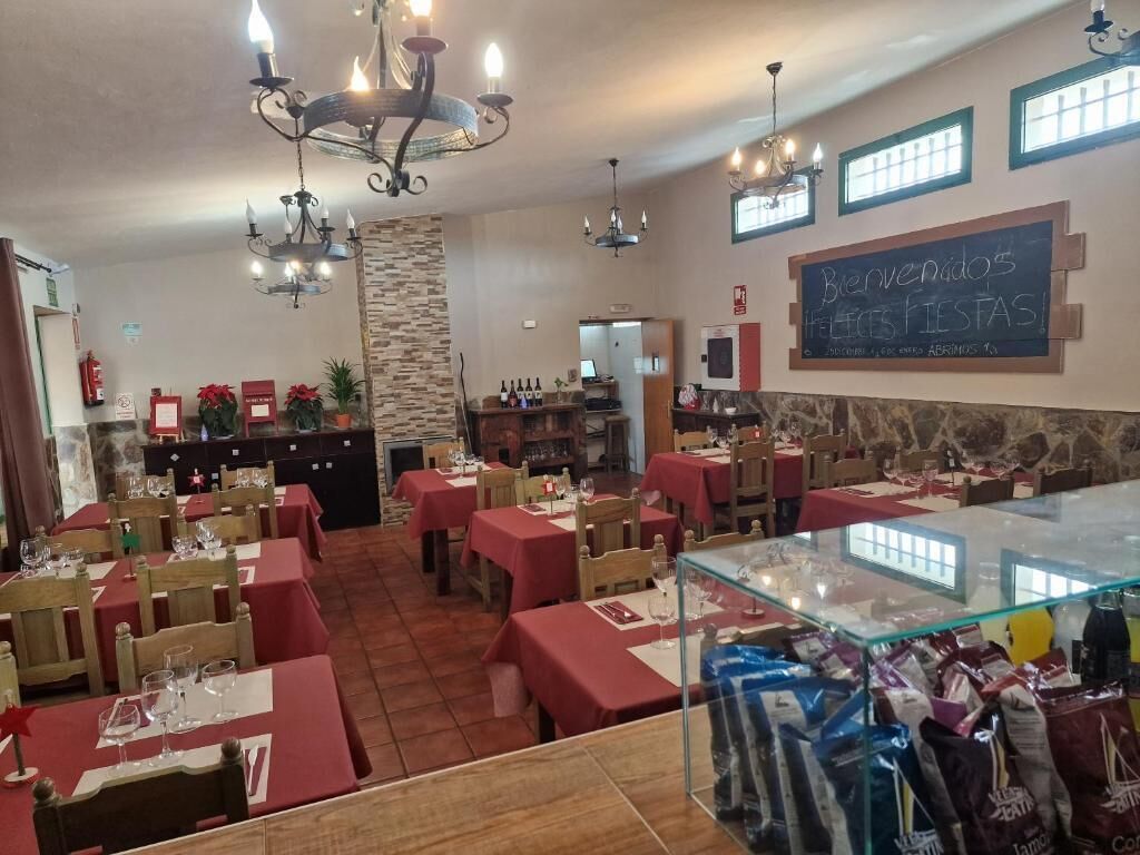 Ein Restaurant mit mehreren Tischen, einer Bar und einer Tafel.