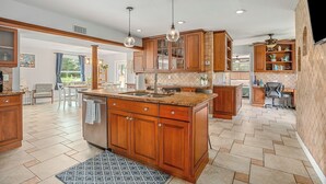 A spacious kitchen with wooden cabinets, a large island, and pendant lighting. - Lakefront Getaway 10 minutes from downtown Deland (DeLand)