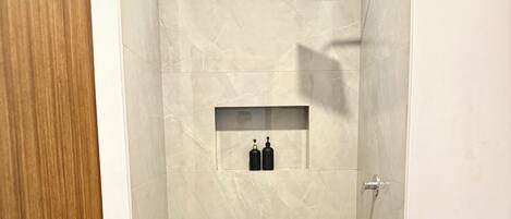 A modern bathroom with a toilet, a shower area, and a vanity.