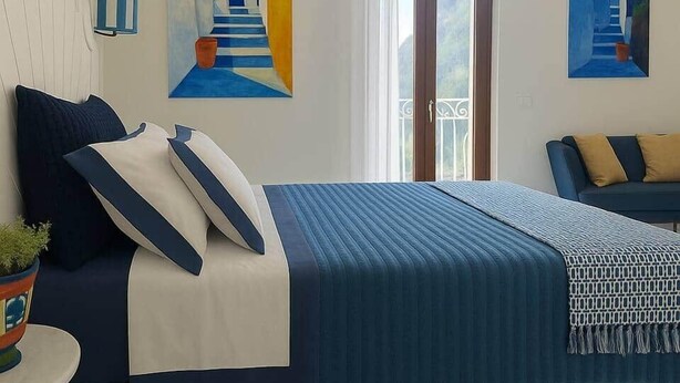 Ein Hotelzimmer mit einem Bett, einer Couch und zwei Bildern an der Wand.