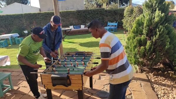 A group of people playing foosball outdoors.