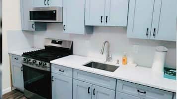 Een magnetron, een oven, een kookplaat, keukenrol