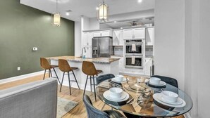 A modern kitchen with white cabinets, a stainless steel refrigerator, and a built-in oven. - Luxury Condo Heart of Downtown / 98/100 Walk Score (Cleveland)