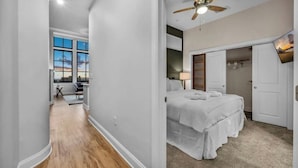 A bedroom with a bed, a ceiling fan, and a view of the outside. - Luxury Condo in Playhouse Square: Walkers Paradise (Cleveland)