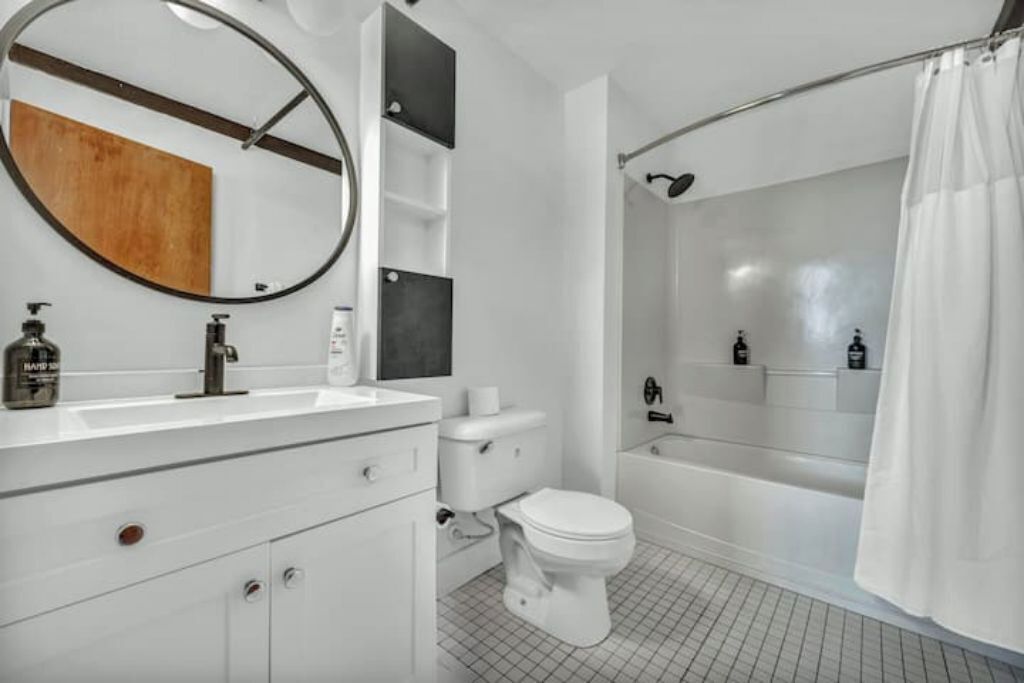 A modern bathroom with a white sink, toilet, and bathtub.