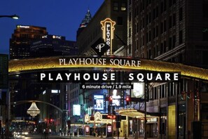 Playhouse Square with a prominent illuminated marquee and a sign indicating a 6-minute drive from the location. - Urban Industrial Penthouse | Game Room Pool Table (Cleveland)