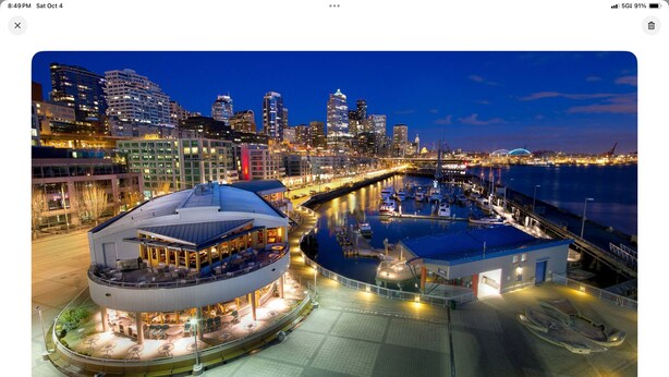 A waterfront hotel with a circular building, a marina, and a city skyline in the background. - Cozy Charming and Central 1-bedroom apartment in Kent (Kent)
