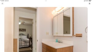 Une chambre à coucher avec un lit, une table de chevet et un miroir.