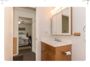 Une chambre à coucher avec un lit, une table de chevet et un miroir.