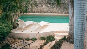 A poolside area with lounge chairs and a small wooden cart. - Casa Kiiwik - Luxury Property with a Private Outdoor Pool and Parking in Central Merida (Mérida)