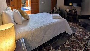 A bedroom with a bed, a TV, a ceiling fan, and a patterned floor. - Casa Axuul - Colonial Property in Central Merida (Merida)