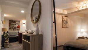 A modern bedroom with a bed, bedside table, and a large mirror. - Chez Corinne et Gilles SPA apartment on the Alsace wine route (Marlenheim)