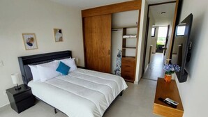 A modern bedroom with a bed, nightstand, wardrobe, and a TV mounted on the wall. - Brisa de Montebello - By Kanaa (Mérida)