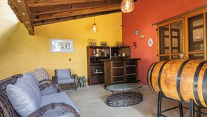 Une pièce chaleureuse, meublée de meubles en osier, avec un tonneau en bois et une petite table.