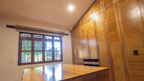 Une cuisine avec des meubles de rangement en bois, un plan de travail et une fenêtre donnant sur un paysage verdoyant.