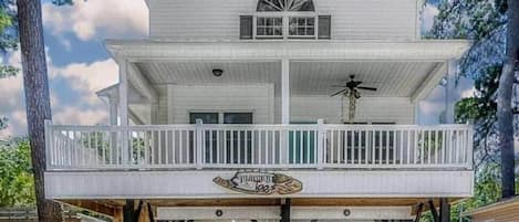 A two-story house with a balcony, a garage, and a sign that reads "The Lodge."