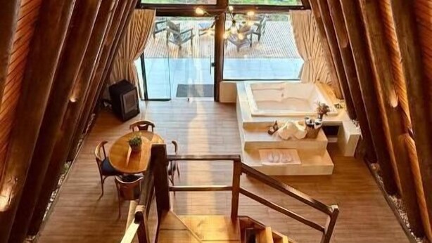 A wooden interior with a staircase leading to a balcony. - Vistas de Mantiqueira (Bom Jardim da Serra)