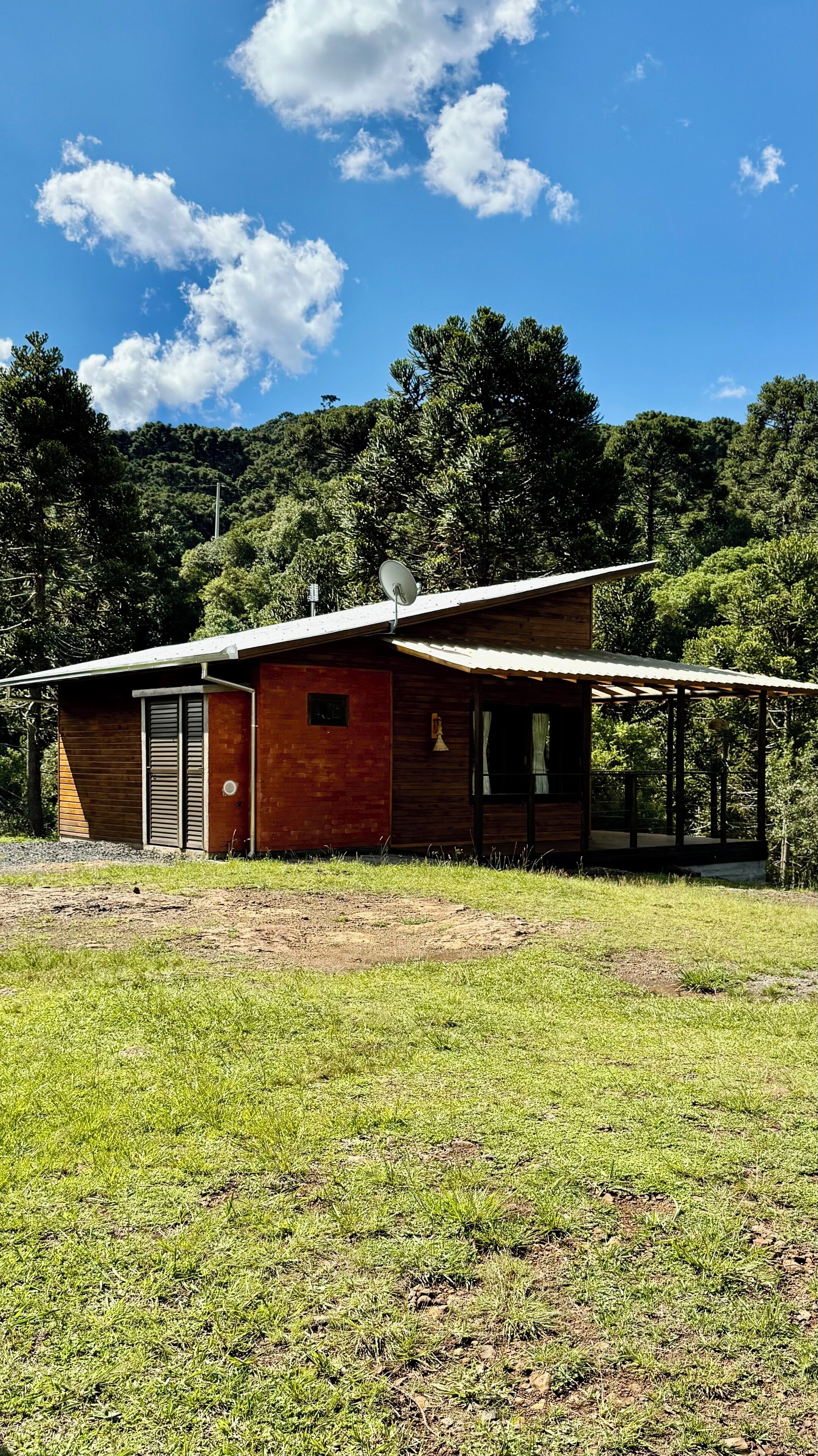 Un pequeño edificio de madera de un piso, con techo de metal y una antena parabólica.