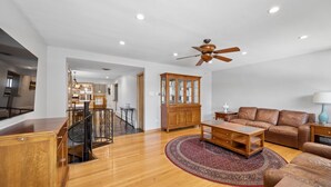 A spacious living room with a wooden coffee table, leather sofa, and a patterned rug. - Spacious Single Family House with Parking (Chicago)