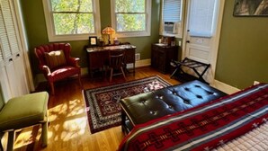 Un dormitorio con cama, escritorio, silla y ventana.