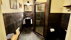 A compact bathroom with a sink, mirror, and shower.