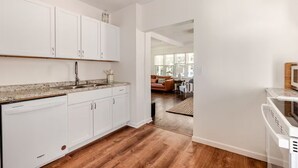 A modern kitchen with white cabinets, a dishwasher, and a microwave. - Cozy Charming 2BR Cottage - Perfect for Traveling Professionals (Grosse Ile)