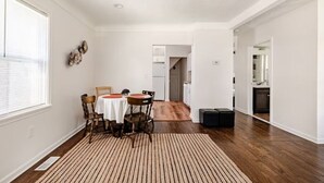 A dining area with a round table, chairs, and a striped rug. - Cozy Charming 2BR Cottage - Perfect for Traveling Professionals (Grosse Ile)