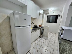 Private kitchen - 01 bedroom with air conditioning, fast Wi-Fi, balcony, swimming pool, close to everything! (Guarujá)
