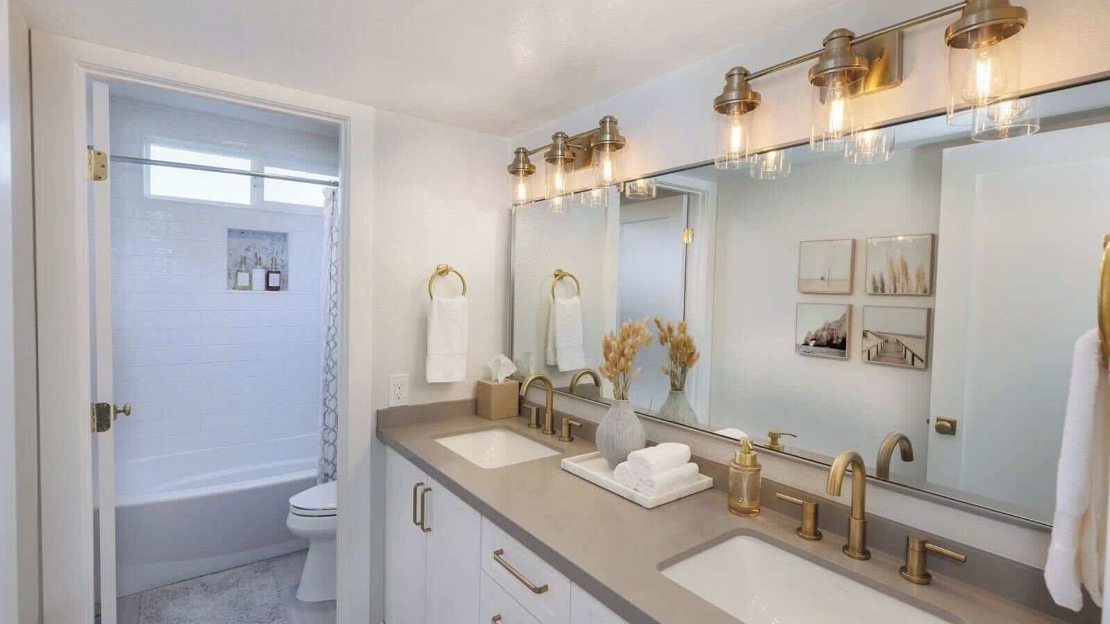 A bathroom with two sinks, a large mirror, and a bathtub.