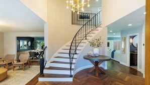 Un intérieur moderne avec un escalier en bois, un coin repas et un espace de vie.