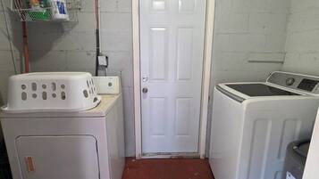 Une buanderie équipée d’un lave-linge, d’un sèche-linge et d’une porte.