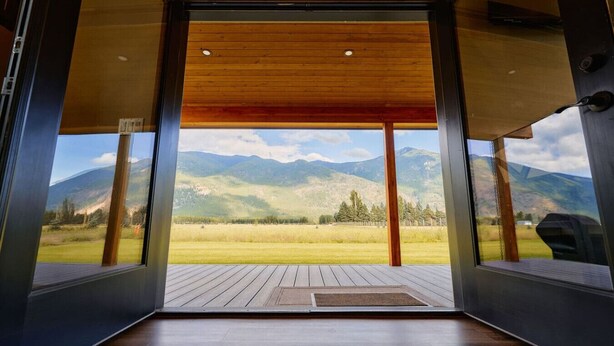 Un interior moderno con techo de madera y ventanas amplias que ofrecen vistas a la montaña.