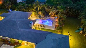 A residential property with a swimming pool, surrounded by lush greenery and a well-maintained lawn. - 7000sf Mansion w/ Pool/Gameroom/Theater - N (Davie)