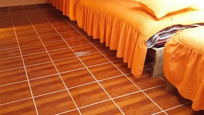 Ein Zimmer mit zwei Betten, Holzbalken an der Decke und einem Fernseher an der Wand.