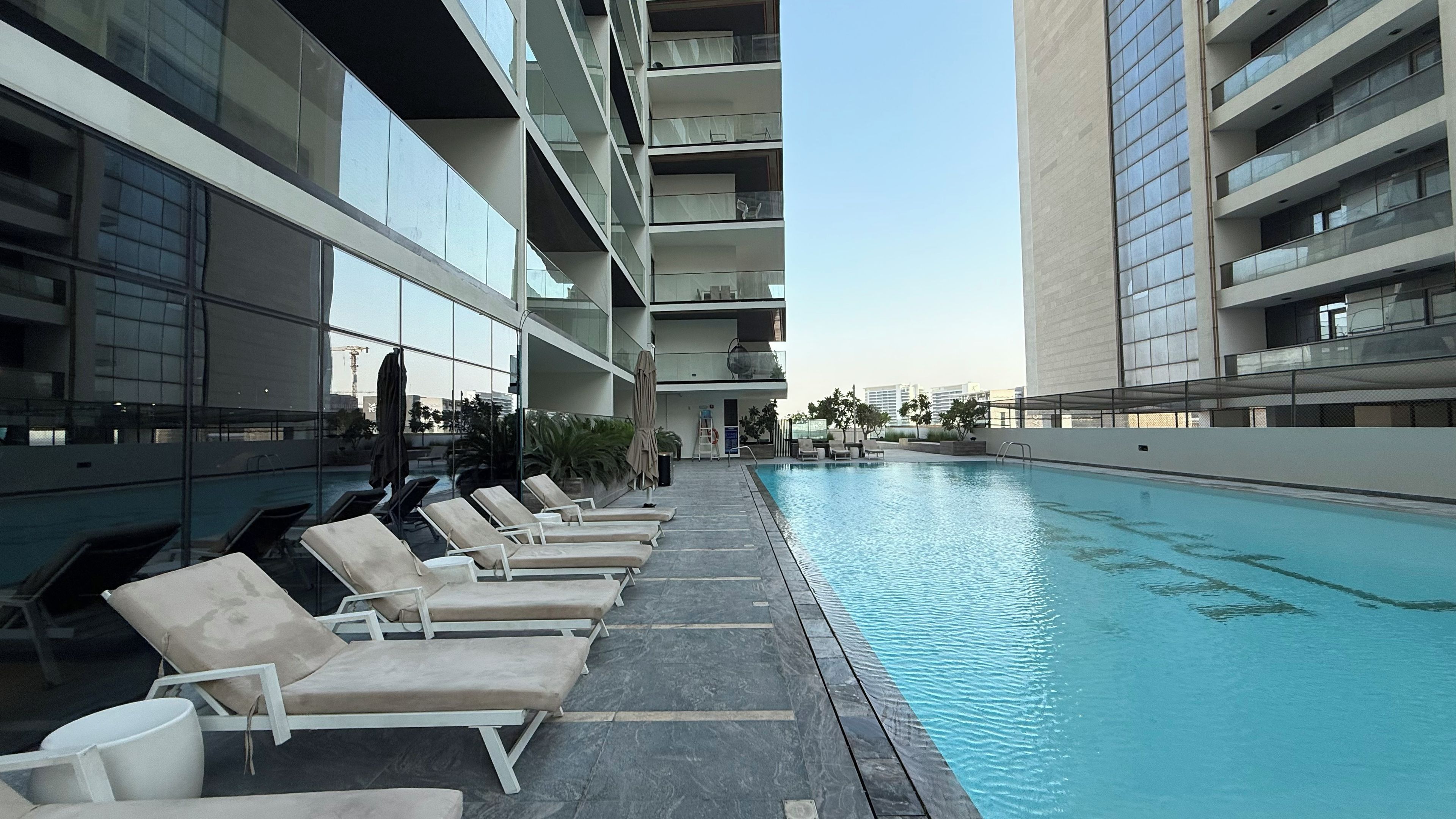 A modern hotel pool area with lounge chairs and a clear view of the pool.