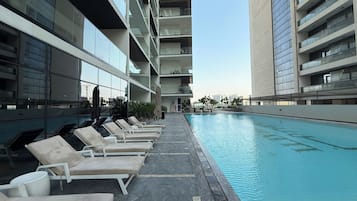A modern hotel pool area with lounge chairs and a clear view of the pool.