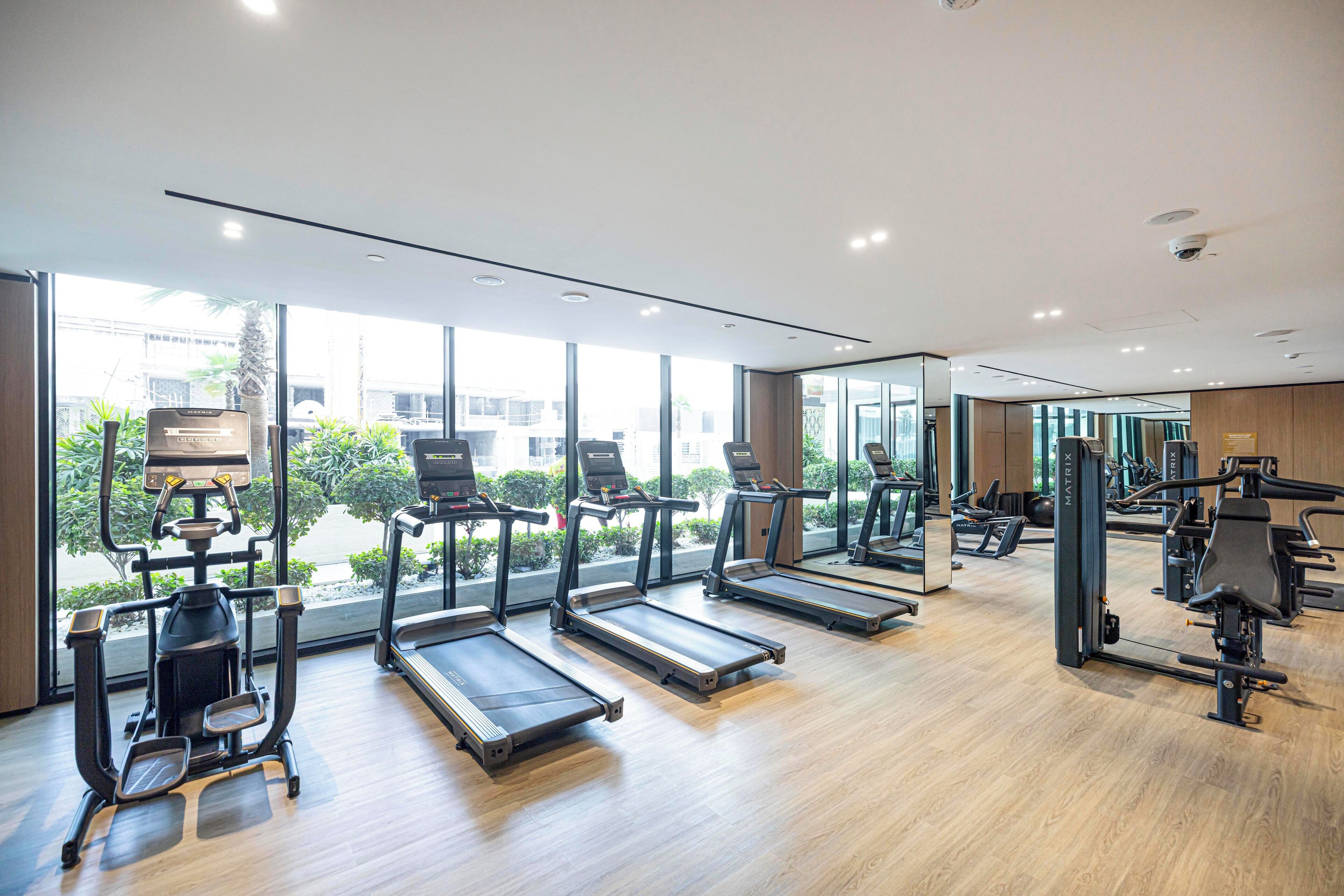 Een fitnessruimte met loopbanden, krachttoestellen en trainingsapparatuur.