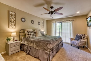 A bedroom with a bed, a nightstand, a chair, a ceiling fan, and decorative wall art. - Deer & Doe-Fire Pit-Private 3 Acres-2 Living Rooms (Sevierville)