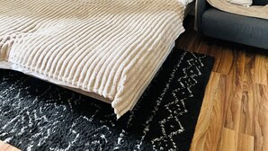 Camera da letto con un letto, un comodino e un quadro di Parigi.