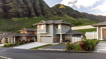 Zona residencial con casas, un camino de entrada y montañas al fondo.