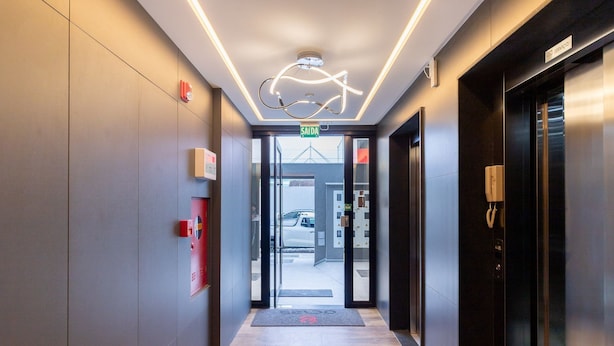 A modern hotel lobby with a glass entrance, a fire alarm, and a service phone. - Your Exclusive Stay in Blumenau, 350m From Vila Germanica - Ocns (Blumenau)