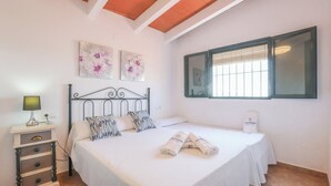 A bedroom with a bed, a nightstand, a lamp, and artwork on the wall. - Casa Rural Los Conde Guadalcanal by Ruralidays (Sevilla)